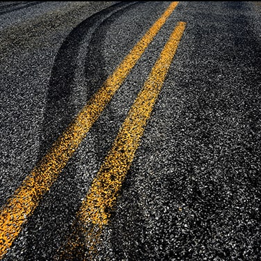 Skid marks on a highway where an impaired driver swerved off of the road